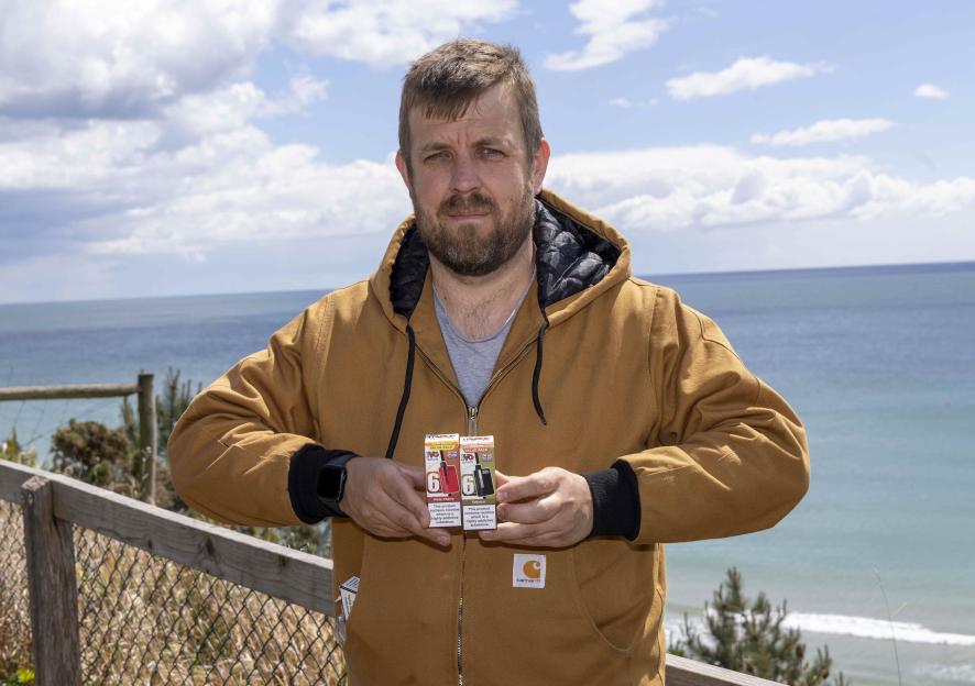 Ben Endley, a Sun feature writer, holds two vape boxes while standing outdoors.