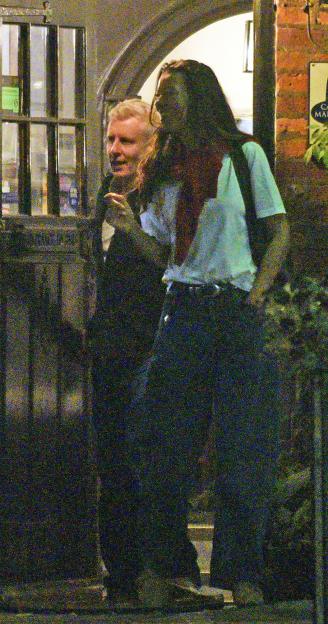 TV presenter Patrick Kielty smiles while leaving a pub with a tall brunette.