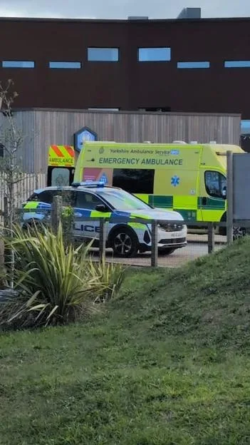 An emergency ambulance and a police car parked outside the Yorkshire Wildlife Park.