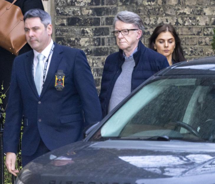 Peter Mandelson leaving his London home with police officers.