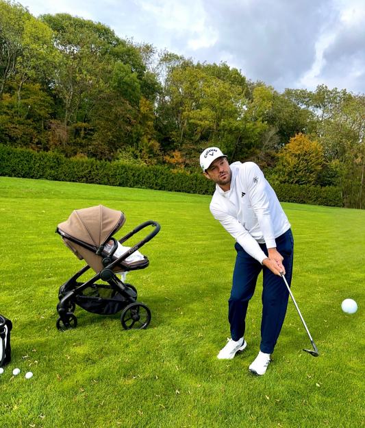 Mark Wright plays golf with his baby daughter Palma nearby in a stroller.