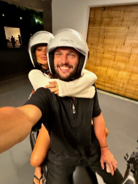 Andy Carroll and Lou Teasdale taking a selfie on a scooter.