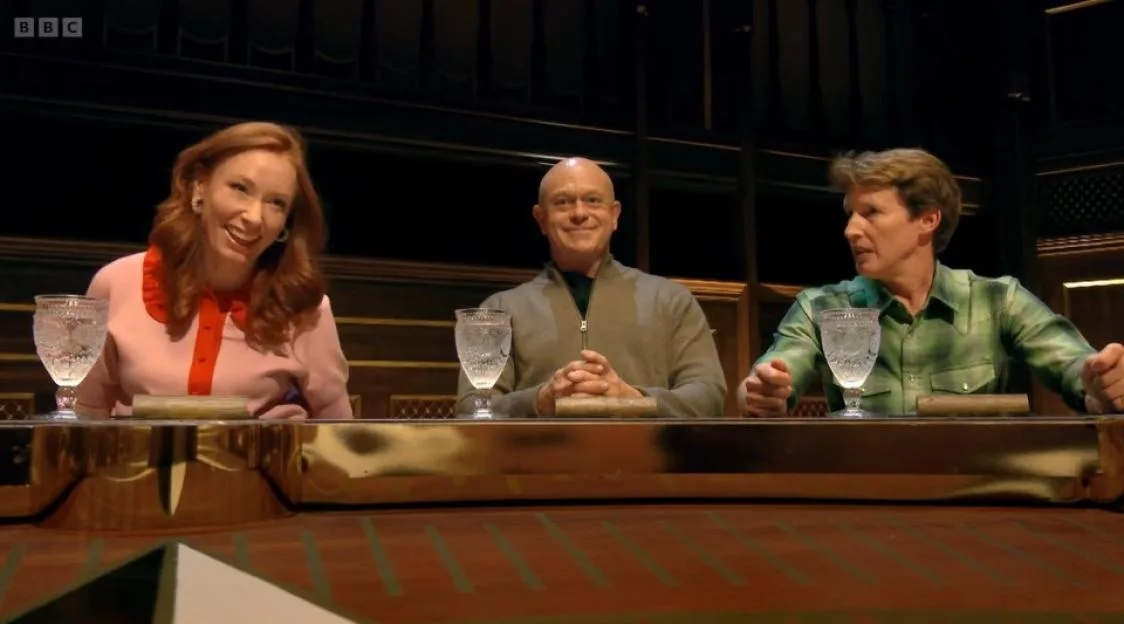Hannah Fry, Ross Kemp, and James Blunt sitting at a table with glasses of water in front of them.