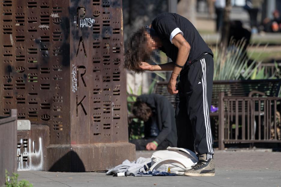 Two individuals, possibly drug users, in MacArthur Park, Los Angeles.
