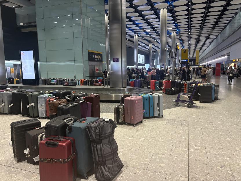 Piles of unclaimed luggage by a baggage carousel at London Heathrow Terminal 5.