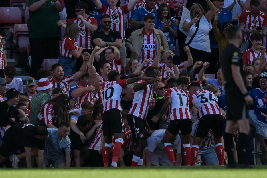 Sunderland fans celebrating a goal, collapsing advertising hoardings, at the Stadium of Light.