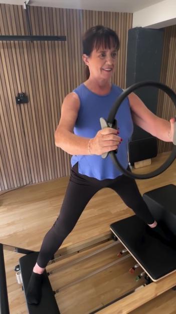 Coleen Nolan exercising on a Pilates reformer.
