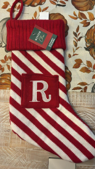 A red and white striped Christmas stocking with a tag that reads "Winter Clara Alphabet Stocking" and a white letter "R" embroidered on a red patch.