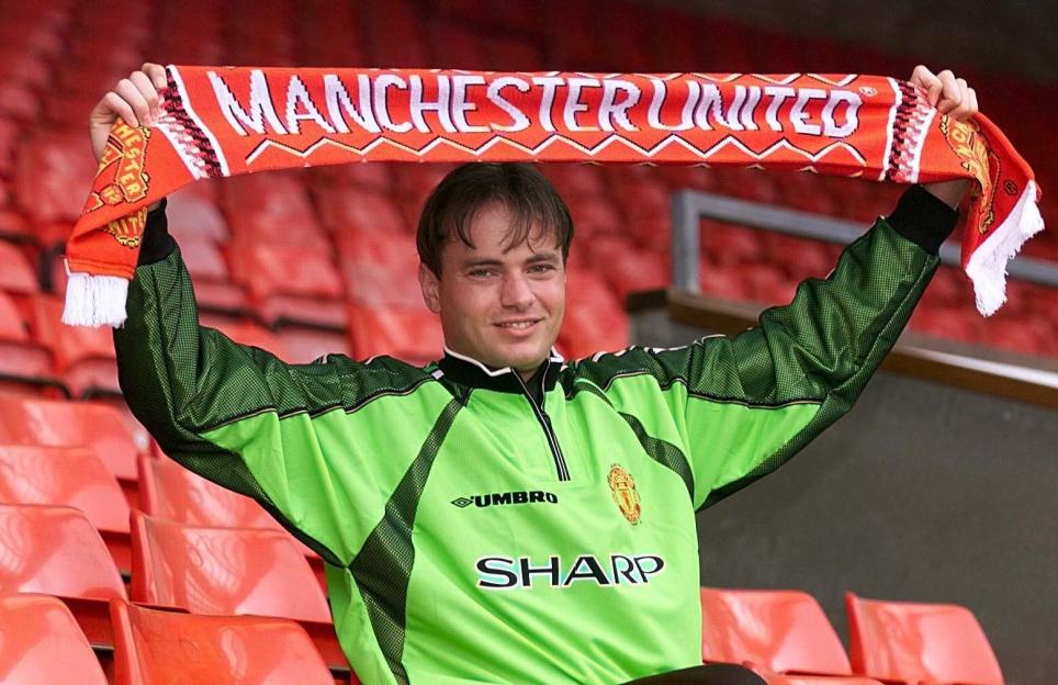 Raimond van der Gouw holding a Manchester United scarf.