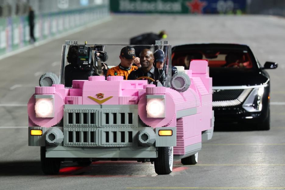 Terry Crews and another man driving a pink Lego Cadillac at the F1 Grand Prix of Las Vegas.