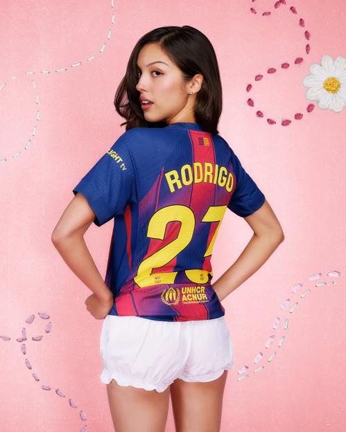 Olivia Rodrigo wearing a Barcelona football shirt with "RODRIGO" and the number 21 on the back.