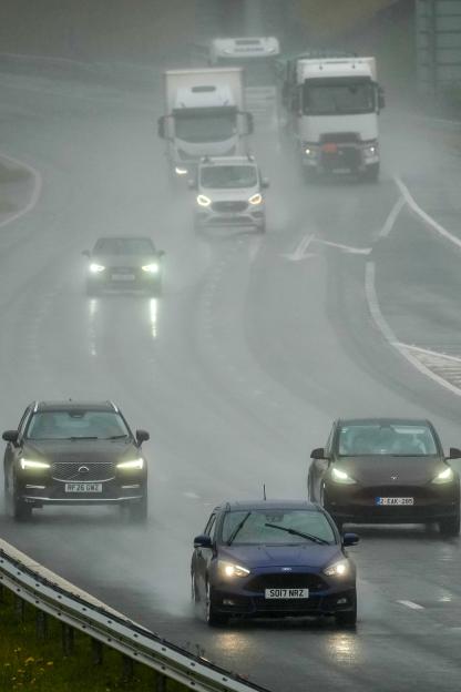 Motorists drive on the M6 motorway at Shap Summit in heavy rain and spray.