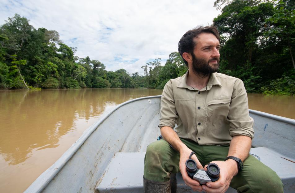 Dr Tim Cockerill on a boat holding binoculars.
