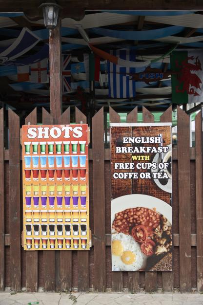 a sign for shots and a sign for english breakfast with free cups of coffee or tea