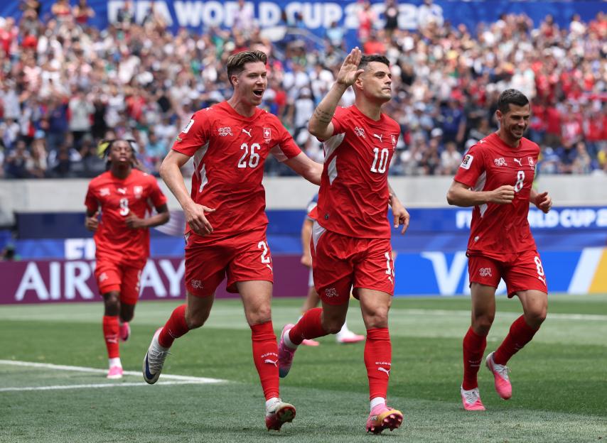 Granit Xhaka and teammates in red uniforms celebrating a goal during the FIFA World Cup 2026.