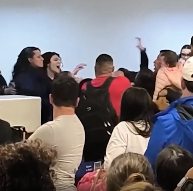 A woman passenger shouting at staff behind a check-in counter before punching a female employee in the face.