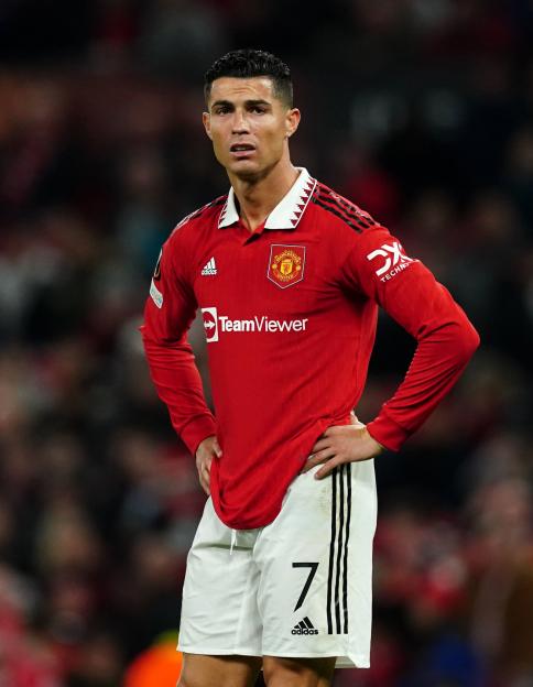 Cristiano Ronaldo in a red Manchester United jersey and white shorts, number 7, with hands on his hips.