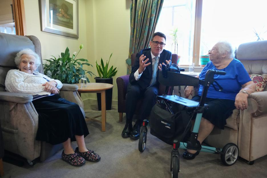 Britain's Prime Minister Andy Burnham speaks to residents during a care home visit.