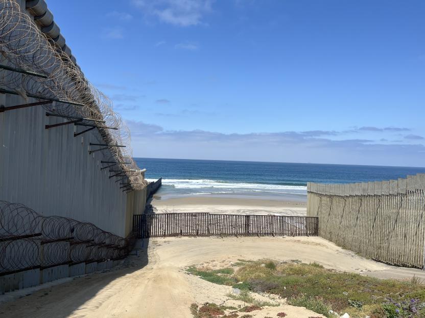 The US-Mexico border wall extending into the ocean at Imperial Beach, California.