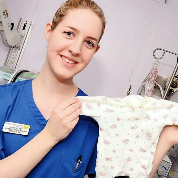 Nurse Lucy Letby holding a baby's floral sleepsuit.
