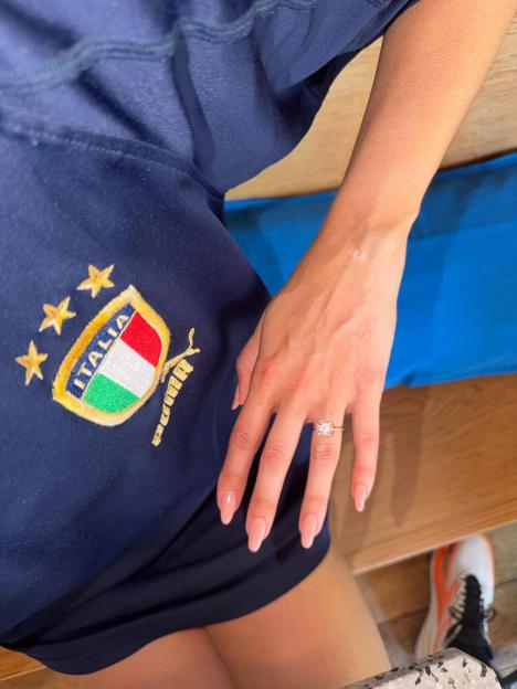 Ana Villafañe's left hand wearing a diamond engagement ring, shown over a dark blue shirt with "ITALIA" and the Italian flag logo.