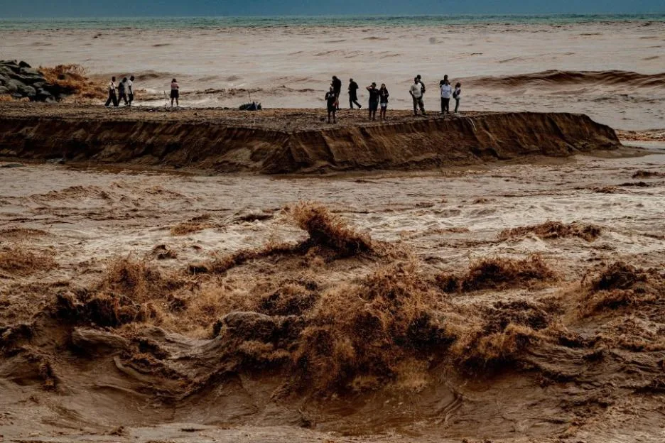 Sant Adria del Besos, Barcelona, ??Spain. October 4, 2026: People stays at the mouth of the Besos River, north of Barcelona, swollen and laden with sediment after a night of torrential rain across Catalonia. The storm brought exceptional rainfall to