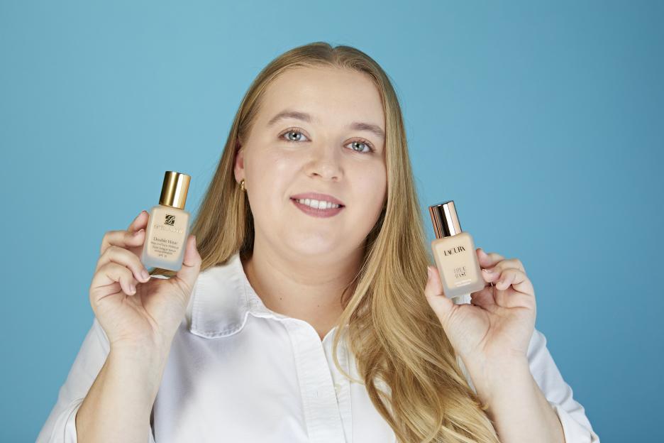 Tara Ledden holding two different foundation bottles, Estee Lauder on the left and Lacura on the right.
