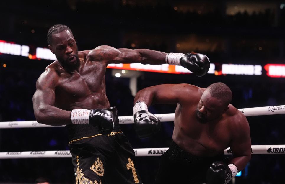 Deontay Wilder throwing a punch at Derek Chisora during their boxing match.