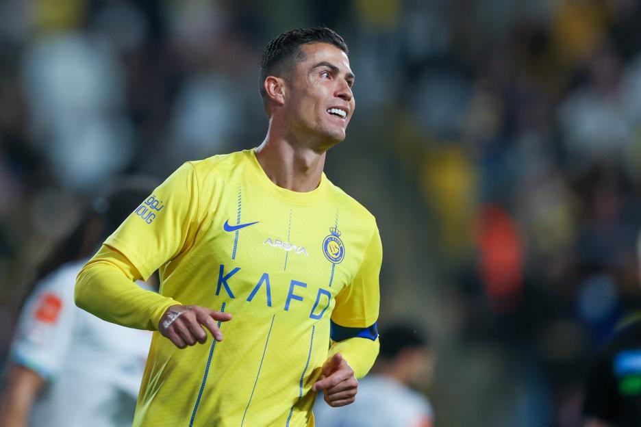 Cristiano Ronaldo in a yellow Al-Nassr jersey during a match against Al Fateh.