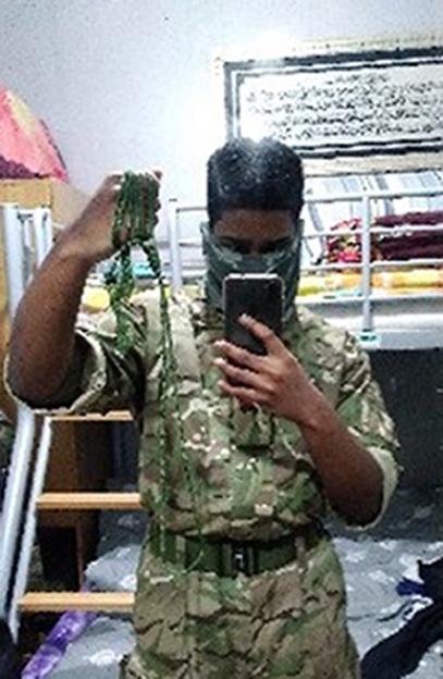 Dihan Rahman in camouflage clothing holding a rope noose.