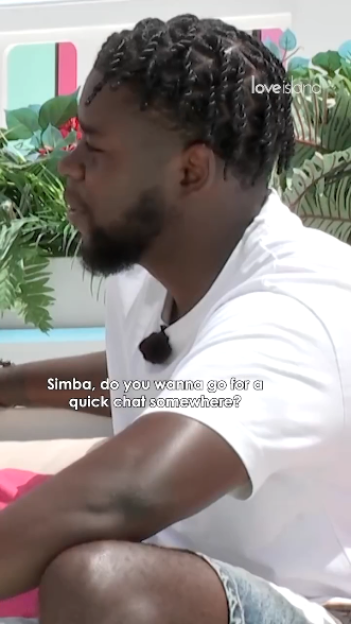 Simba from Love Island is interviewed, a microphone clipped to his white T-shirt.