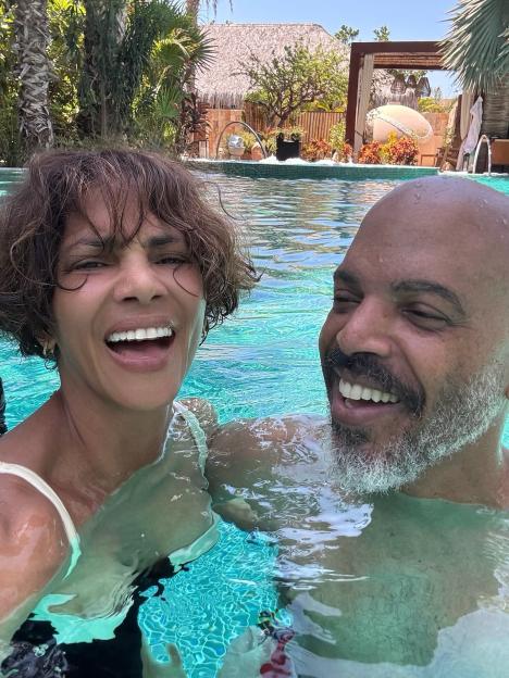 Halle Berry and Van Hunt smiling in a swimming pool.