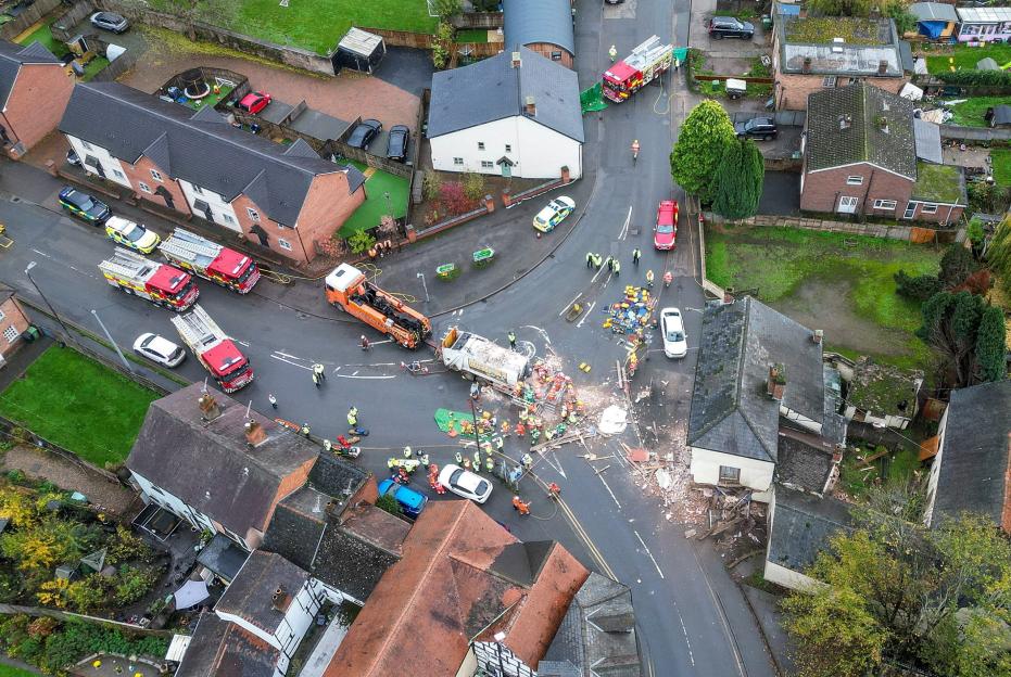 Emergency services rush to street after bin lorry smashes through side of house