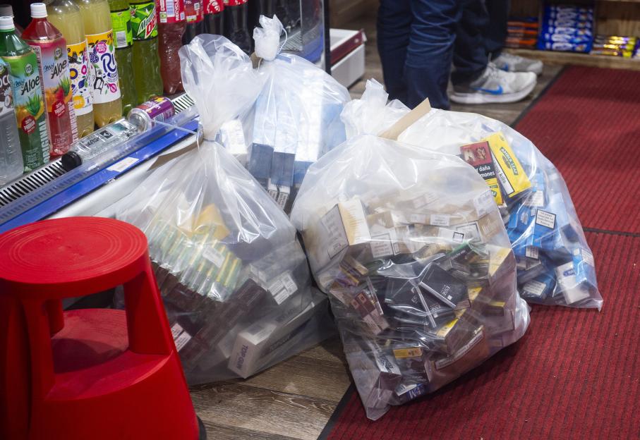 Large bags filled with seized cigarettes and illegal vapes.