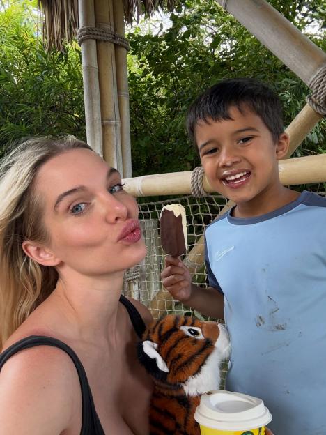 Helen Flanagan taking a selfie with a boy who is eating an ice cream bar.