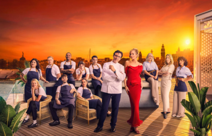 The cast of "The Parisian Agency: Exclusive Properties" stands on a deck overlooking a city at sunset.