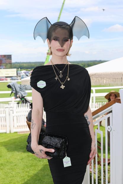 Kelly Osbourne wearing a black dress and a bat-wing fascinator at Royal Ascot.