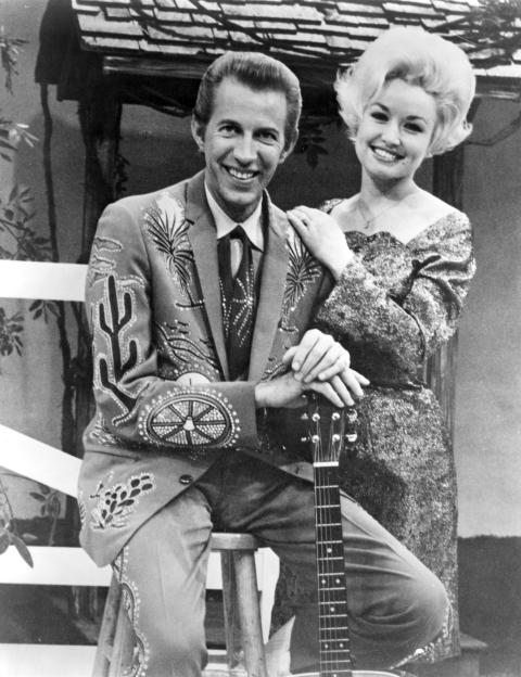 Dolly Parton and Porter Wagoner smiling.