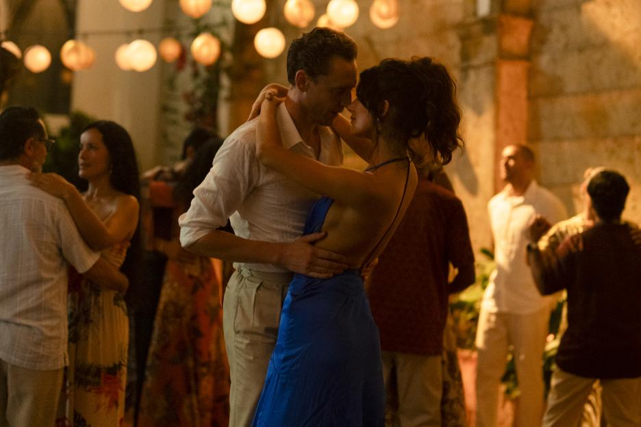 Jonathan Pine (Tom Hiddleston) and Roxana (Camila Morrone) dancing at a party.