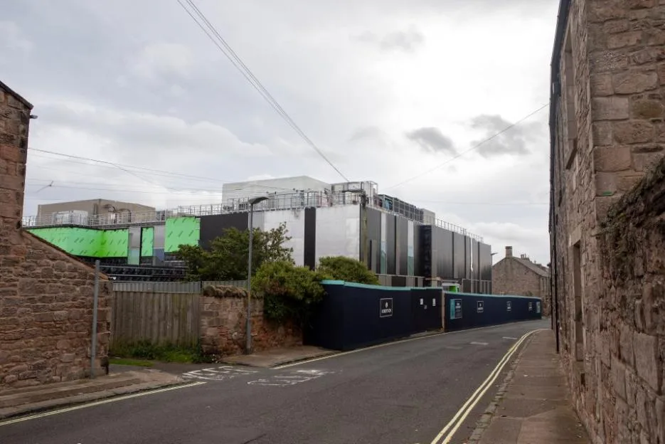 The Berwick Community Hospital construction site towering over a narrow street.