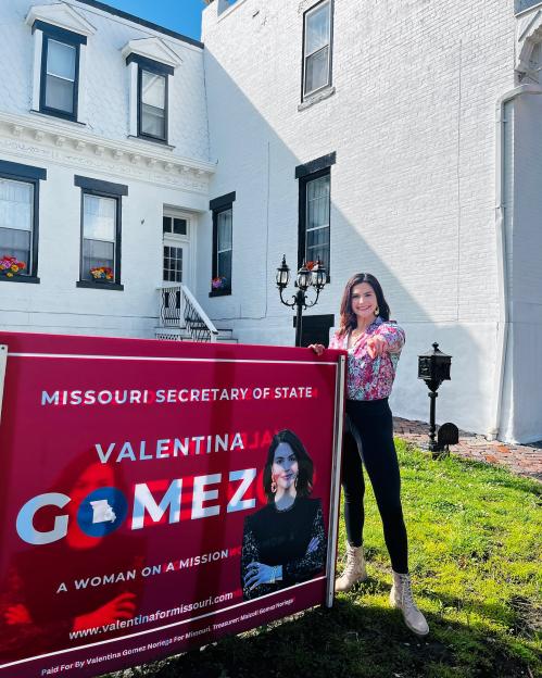 Valentina Gomez, a Republican candidate for Missouri Secretary of State, stands next to her campaign sign.