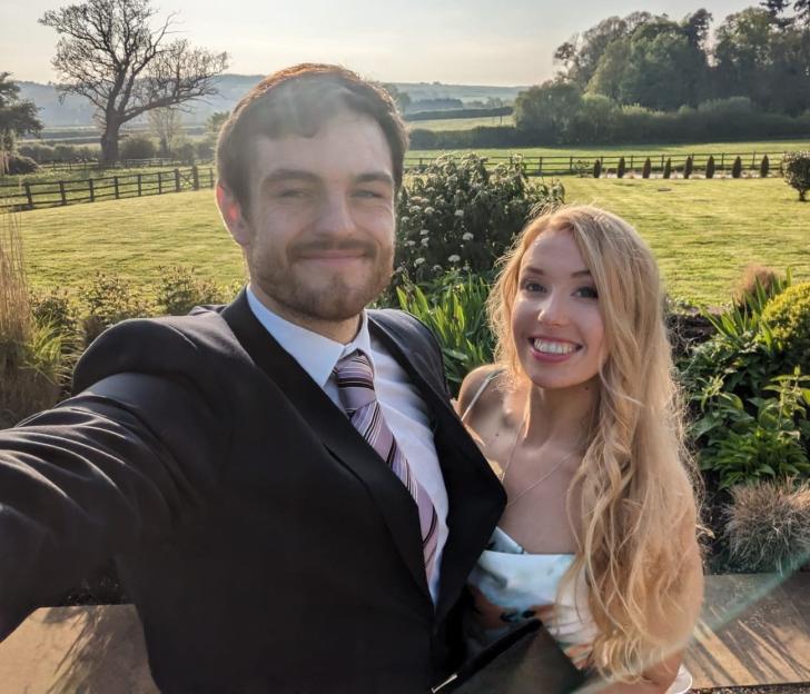 Tom Davies with his girlfriend Alex Ross, smiling at the camera outdoors.