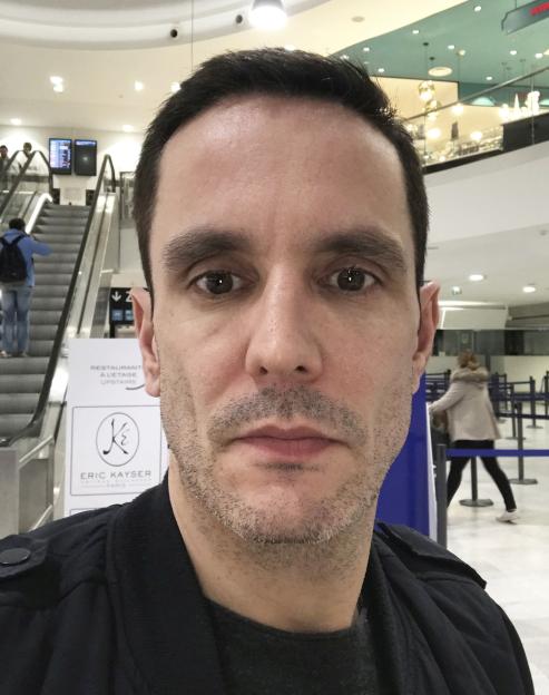 Alastair Wallace before his fall, wearing a black jacket and a dark shirt.