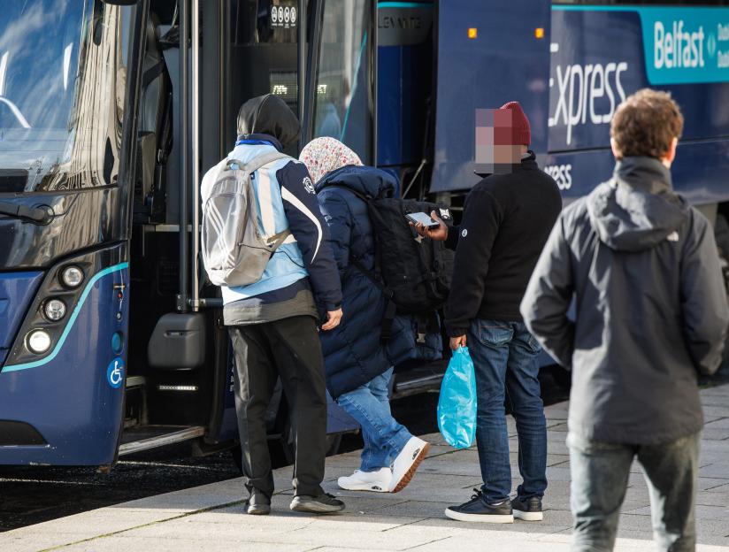 People queuing to board a bus in Dublin to Northern Ireland.