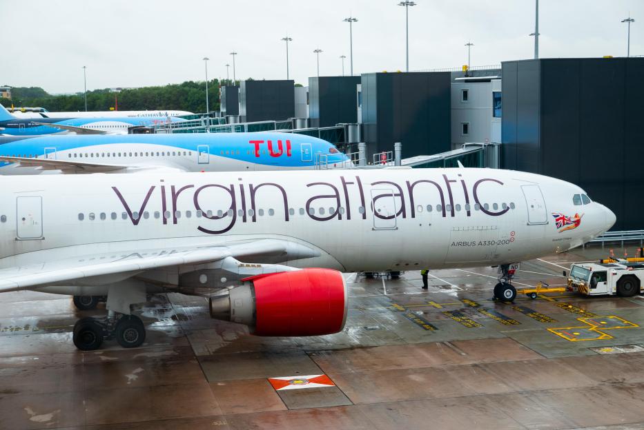 Virgin Atlantic and TUI planes parked at an airport gate.