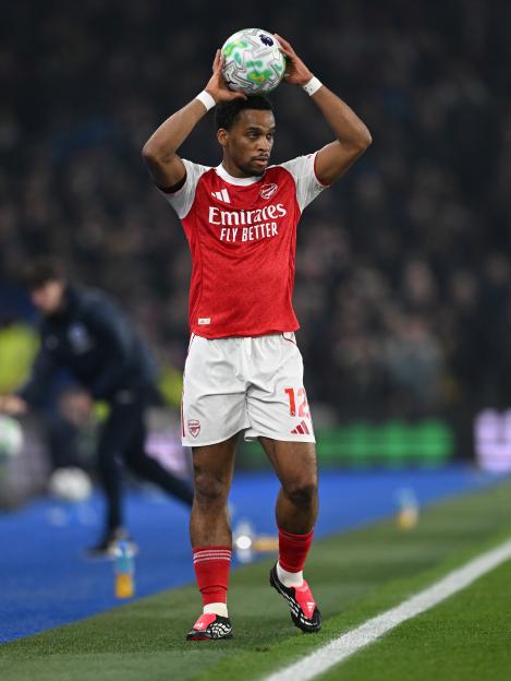 Jurrien Timber of Arsenal holding a soccer ball above his head.