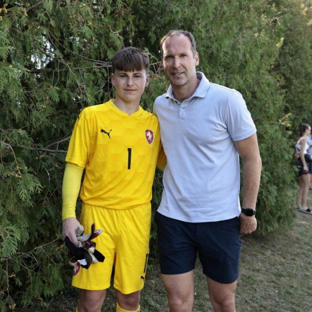 Petr Cech posing with a young goalkeeper in a yellow kit.