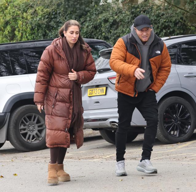 Stacey Solomon and Joe Swash walking with cars in the background.