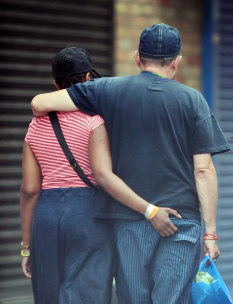Damon Albarn and Rebecca Freckleton walking together with arms around each other.