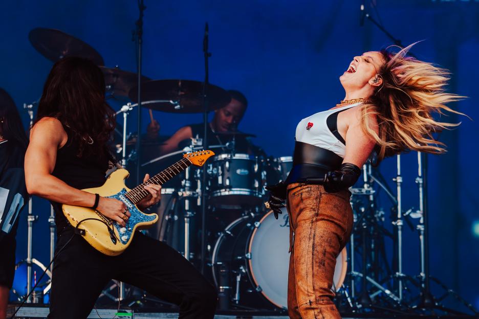 Perrie performs at Mighty Hoopla with a guitarist and drummer behind her.